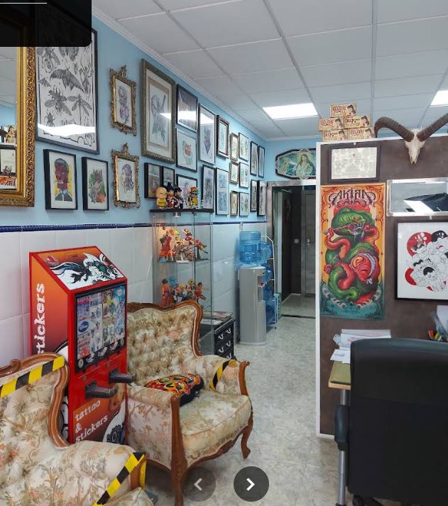Interior del estudio: sillones vintage, vitrina de figuras y paredes cubiertas de flash art