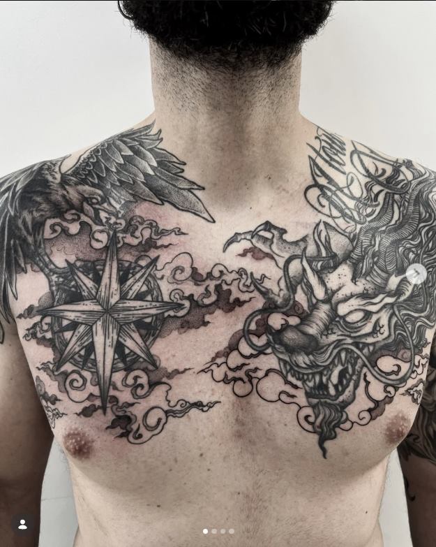 Pieza de pecho en blackwork con cuervo, dragón y rosa de los vientos